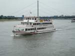 Ein Ausflugsschiff vor der Rheinpromanade in Dsseldorf mit der Oberkasseler Brcke im Hintergrund am 26.06.2004.