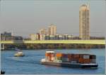 Voll mit Container beladen fährt das Schiff  TRIFELS  auf dem Rhein in Köln der untergehenden Sonne entgegen.