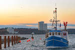 Fischereifahrzeug NIE 1 KYRA HAUSWALD im Licht der untergehenden Sonne am 26.01.2021 in Niendorf/Ostsee einlaufend