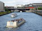 Reger Schiffsverkehr auf der Spree. Kurz hinter den Bauten des Regierungsviertel liegt in stlicher Richtung der Bahnhof Friedrichstr. Teile des Bahnsteigs reichen bis weit ber den Flu. Foto: 14.8.2006