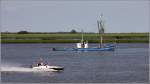 Arbeit und Vergngen auf dem Wasser. Whrend der Fischer auf der BRA 1 FREIHEIT am Nordende der Weserinsel Harriersand seiner Arbeit nachgeht, haben die vier jungen Mnner auf ihrem Motorboot offensichtlich viel Spa. 01.08.2012