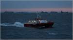 Vor Sonnenaufgang: Der Lotsenversetzer WANGEROOG (IMO 9569011) ist in der Auenweser unterwegs. Im Hintergrund auf Reede liegende Schiffe, die darauf warten, in die Hfen an der Weser einzulaufen. Am 05.05.2017 gegen 5:30 Uhr vor Wangerooge. Das Bildrauschen ist ISO 6400 geschuldet.