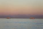 Im Licht der untergehenden Sonne: 2 Schiffe der Fhrverbindung Konstanz - Meersburg, von der Mainau aus gesehen am 04.09.2013
