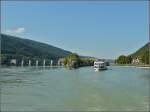 Das Motorschiff Passau auf der Donau, im Hintergrund ist das Wasserkraftwerk Jochenstein mit der Schleuse an der deutsch - östereichichen Grenze zu erkennen.