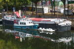 Das Theaterschiff MARIA-HELENA (Kennung SBD 154) am Willi-Graf-Ufer in Saarbr�cken. Gebaut wurde es 1911 als Frachtschiff (P�niche) auf der Werft Pauly in Stra�burg. Neben ihm ein evtl. als Hausboot genutztes �lteres Begleitboot. Aufnahmedatum: 28.09.2026.