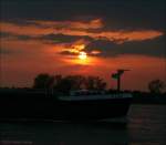 Jenseits von Afrika - Die  Febe  passiert im Sonnenuntergang den Rhein bei Duisburg-Schwelgern.