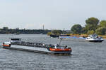 Das Tankmotorschiff SYNTHESE 16 (ENI: 02334334) auf dem Rhein, im Hintergrund das Gütermotorschiff DEVOTION (ENI: 06003854) bei der Anfahrt des D3T Duisburg Trimodal Terminals.