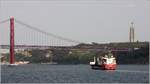 Die 2007 gebaute HOLLANDIA (IMO 9374973) steuert am 21.04.2017 auf dem Tejo Lissabon an. Die Brücke des 25. April und die Cristo Rei Statue in Almada sind bereits in Sicht. Die HOLLANDIA ist 142,95 m lang und 18.90 m breit, hat eine GT/BRZ von 8.999 und eine DWT von 12.016 t. Sie kann auch 686 TEI transportieren. Die beiden Krane können je 80 t heben. Heimathafen ist Rotterdam (Niederlande). Frühere Namen: TRINITAS, NIRINT HOLLANDIA.