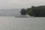 Das Motorschiff  Weggis  bernachtet momentan fast tglich in Brunnen. Am 24.9.2010 wurde die abendliche Rckfahrt dorthin (Kurs 27) allerdings durch den einsetzenden starken Regen etwas getrbt, wie diese Aufnahme vor Hertenstein zeigt. 