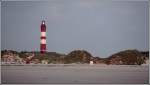 Das Seefeuer Amrum ist seit dem 01.01.1875 in Betrieb; er ist der erste unter deutscher Regierung an der nordfriesischen Kste gebaute Leuchtturm. Der Turm ist 41 m hoch, durch seine Lage auf einer Dne ist sein Feuer jedoch 63 m ber dem Meeresspiegel. Der kleine rot-weie Mast rechts neben dem Turm ist das Oberfeuer der ehemaligen Richtfeuerstrecke Amrum Hafen. Aufnahmedatum: 06.09.2006 in der Dmmerung kurz nach dem Entznden des Feuers.