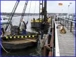 Um den ca. 5m im Untergrund steckenden hlzernen Poller anheben zu knnen, wird hier im Bild mit Hilfe einer Wasserlanze die Umgebung des Baumstamms ausgesplt. Foto: 27.02.2008