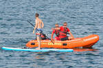Besatzung eines DLRG-Bootes weist einen Stand up-Paddler an, die Gefahrenzone (Fahrwasser-Bereich für Seeschiffe) zu verlassen.