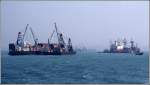 Kaimauern scheinen in Hong Kong Mangelware zu sein, denn viele Schiffe werden mit Hilfe von Leichtern und Schwimmkrnen be- bzw. entladen. Scan eines Dias aus dem Januar 1997.