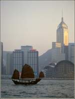Gelegentlich sind auch noch traditionelle Dschunken im Hafen von Hong Kong zu sehen - so wie hier vor der Skyline von Hong Kong Island. Scan eines Dias aus dem Januar 1997.
