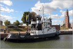 Der 1983 gebaute Schlepper BRAKE (IMO 8223036) liegt am 05.10.2016 im Neuen Hafen von Bremerhaven. Rechts im Bild ist der Simon-Loschen-Leuchtturm, das Oberfeuer Bremerhaven, zu sehen. Die BRAKE ist 28,16 m lang und 8,80 m breit. Die Maschinenleistung beträgt 2 x 800 kW, der Pfahlzug 25,5 t. Heimathafen ist Bremen. Frühere Namen: MIDGARD III, BRAKE, ROMAN.