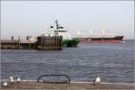 Während das Zollschiff HELGOLAND um das grüne Molenfeuer herum in den Hafen von Cuxhaven einläuft fährt die BABUZA WISDOM weiter Elbe aufwärts. 24.02.2014