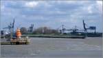 Die Zufahrt zum Auenhafen in Emden wird von zwei Molenfeuern flankiert. Links das markante, in Signalfarbe gestrichene westliche Molenfeuer. Scan eines Dias aus dem April 2005.