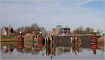 Das Außenhaupt der Großen Seeschleuse in Emden mit der Hafenbetriebszentrale in der Bildmitte und dem Lotsenhaus am linken Bildrand. Die Zufahrt zur Schleuse wird von markanten Dalben flankiert. 24.02.2019 