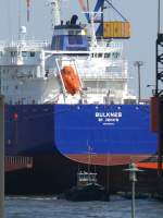 Imposant ist das Größenverhältnis von SCHLEPPKO 7 zum Heck des Massengutfrachters BULKNES, St. JOHN´S (IMO 9384370), L: 176m, B: 26,0m; gebaut 2009 bei SIETAS Schiffswerft Hamburg, Flagge: Antigua and Barbadu; im Hamburger Hafen, 16.04.2009

