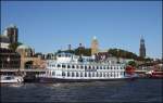 Altes Schiff mit moderner Technik! Der  Raddampfer  Louisiana Star wurde eigens für Rundfahrten in Hamburg gebaut. Das Schaufelrad dient nur als optischer Hingucker. In Wirklichkeit treiben moderne Dieselmotoren das Schiff an. Am 11.10.2015 lag es an den Landungsbrücken in Hamburg mit dem Wahrzeichen, dem Hamburger Michel, im Hintergrund.