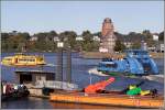 Farbenfroh sind viele der Hamburger Hafenfhren. Diese beiden fahren vom Anleger in Finkenwerder am Seemannshft vorbei zurck in die Elbe. Im Vordergrund ist ein Teil des Tonnehafens der Hamburg Port Authority (HPA)zu sehen. Aufnahmedatum: 16.10.2005