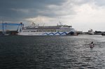 Während die MS Europa im Hintergrund noch festvertäut am Kieler Ostseekai liegt, verlässt AIDAaura am 22.5.2016 ihren Liegeplatz 