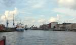 Lübeck Burgtorhafen, das Motorschiff Till ist zur Zeit aufgelegt und liegt am LMG-Kai. Die Kraweel  LISA von LÜBECK  kommt von See und das Absenken der Klappe von der Eric Warburg-Brücke ist in der Bildmitte erkennbar. Aufgenommen: 31.7.2011