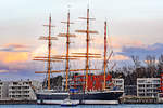 Polizeiboot HABICHT fährt im Licht der untergehenden Sonne an der Viermastbark PASSAT vorbei. Lübeck-Travemünde, 14.03.2021