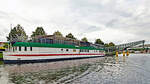 Das Betonschiff RIVERBOAT am 14.08.2021 in Lübeck. Es befindet sich seit den 1950er-Jahren in der Hansestadt und ist 55 Meter lang und 7,5 Meter breit. Es wurde 1942 von DYWIDAG (Dyckerhoff & Widmann) in Holland gebaut. Dieses Schiff bzw. dieser  Schwimmkörper , wie es korrekt heißen muss, denn es verfügte nie über einen eigenen Antrieb, wurde ausschließlich geschleppt und sollte schweres Kriegsgerät über den Kanal bringen. Nach Ende des Zweiten Weltkriegs diente es als Auffangstation für Flüchtlinge. 1956 wurde es unter der Lübecker Puppenbrücke vertäut und als Musikschiff (vor allem Jazz) eröffnet. 1978 wurde das Schiff auf die andere Seite des Holstentores, in den Holstenhafen, verbracht und als Diskothek wiedereröffnet. Als nach mehreren Anläufen auch hier der Erfolg langsam ausblieb, wurde das RIVERBOAT ein weiteres Mal verlegt;in den Klughafen (1994). Nach großen Umbau- und Sanierungsmaßnahmen öffnete im April 2007 das  neue  RIVERBOAT, jedoch nicht mehr als Diskothek, sondern als Veranstaltungszentrum. Das Restaurant  Seaside  bietet hier nunmehr  italienische Küche 