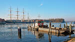 Schubboot LUBA (Europanummer: 05017990) und Ponton TR II am 10.03.2022 im Hafen von Lübeck-Travemünde. Im Hintergrund ist die Viermastbark PASSAT zu sehen.