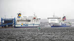 STENA LIVIA (Stena Line, IMO 9420423) am 14.03.2023 bei Ankunft in Lübeck-Travemünde. Starker Regen fällt, als das Schiff kurz vor dem Festmachen am Skandinavienkai ist. Links im Bild: TT-Line-Fähre TOM SAWYER