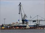 Unter dem Drehwippkran im Hafen von Nordenham steht - kaum zu erkennen - ein Kohlezug, der beladen wird. 01.08.2012