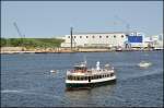 Fahrgastschiff  Kppn' Brass  bei einer Hafenrundfahrt im Seehafen Rostock am 07.07.13 vom Fhrschiff  Prins Joachim  aus aufgenommen. Im Hintergrund die weithin bekannte Neptun-Werft.