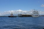 Der Schlepper Bugsier 10 zieht ein Ponton mit Masten für Hochseewindparks durch den Seekanal Warnemünde und begegnet dabei der 3-Mast Bark Artemis.