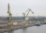 Blick vom Deck der Peter Pan auf 2 typische TAKRAF Hafenkräne in Rostock-Warnemünde.
Im Hintergrund das Küstenmotorschiff Zingst. 01.11.2018  13:58 Uhr.