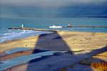 Der lange Schatten des Hotels Neptun weist Richtung Hafenausfahrt  Warnemnde (Dezember 03)
