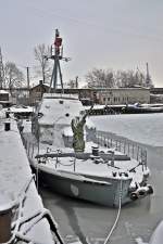 das alte Schnellboot der Bundesmarine im Stralsunder Hafen fest in der Hand von Väterchen Frost, Leck geschlagen durch Eisgang und sieht fast aus wie ein halbes U-Boot im Eismeer, 18.01.2010