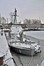 das alte Schnellboot der Bundesmarine im Stralsunder Hafen fest in der Hand von Vterchen Frost, Leck geschlagen durch Eisgang und sieht fast aus wie ein halbes U-Boot im Eismeer, 18.01.2010