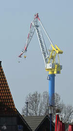 Ein Hafenkran der MV-Werften überragt die Gebäude in Wismar. (März 2022)