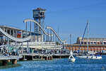 Die 1994 fertiggestellte Fußgängerbrücke Rambla del Mar hat einen drehbaren Teil, welche sich öffnet, wenn Segelboote zum Segelhafen gelangen wollen. (Barcelona, November 2022)