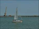 Segelschiff CROESO in der Hafeneinfahrt von Oostende, im Hintergrund sieht man die Schwerlasttransporter und den Raupenkran bei den Arbeiten am Hafen von Oostende.  11.08.2010