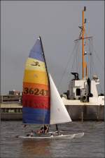 Der kleine Katamaran HELTER SHELTER umschifft den Bagger SEEKRABBE, um in den Hafen von Hooksiel zu gelangen. 20.08.2009