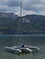 1 Master Segelboot liegt auf dem See von Annecy, unweit vom Ufer.