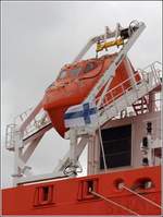 Das Freifallrettungsboot der UIKKO (IMO 9797814). Davor flattert die finnische Flagge im Wind. Bremerhaven, 12.03.2021