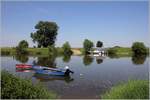 Sommerliche Idylle an der Mittelweser. Im Hintergrund liegt die kleine Solarfähre PetraSolara, im Vordergrund zwei offene Motorboote. Windheim, 07.06.2018
