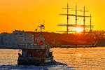 TRA 4 läuft bei untergehender Sonne am 19.01.2020 in den Hafen von Lübeck-Travemünde. Rechts im Bild ist die Viermastbark PASSAT zu sehen.