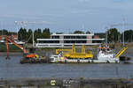 Das Bagger-/Umweltkontrollschiff  Pieter Coecke  (IMO: 9031193) schiebt einen Ponton mit Bagger vor sich her.