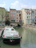 Frankreich, Languedoc-Roussillon, Aude, Narbonne, Cours Mirabeau, Hausboot  Pays d'Oc  auf dem Kanal der Robine. Im Hintergrund eine der in Frankreich seltenen überdeckten Brücken über den Kanal. 14.04.2004
