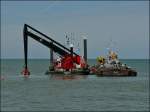 Hier positionniert der Schwimmkran einen grossen Felsbrocken im Wasser in der Nhe der Hafeneinfahrt von Oostende.