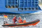 Boot der WASSERWACHT am 04.09.2021 im Hafen von Lübeck-Travemünde unweit der in Richtung Ostsee steuernden JUTLANDIA SEA